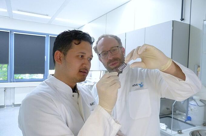 Tengku Ibrahim Maulana (links) und Prof. Peter Loskill, mit dem Chip, der Chancen eröffnet: Darauf lässt sich Tumorgewebe züchten, mit Zelltherapeutika behandeln und dann die Reaktion beobachten. Ein Schritt zu wirksameren und schonenderen Behandlungen | Copyright: Foto: NMI |